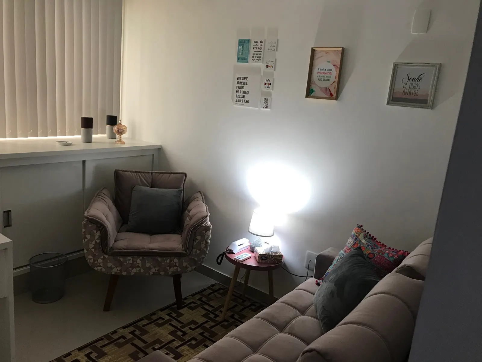 Consultório de psicologia com poltrona, sofá e quadros na Vila da Penha